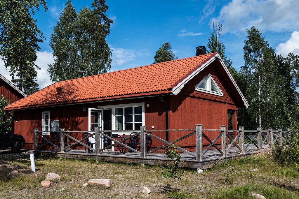 Rött svenskt fritidshus i skogsmiljö